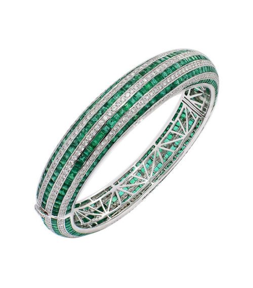 A bangle made up of multiple parallel rows. Alternating rows consist of rectangular - cut emeralds and rows of diamonds, creating a striped pattern. The inside of the bangle shows an intricate lattice - like structure, all crafted with high - quality materials.