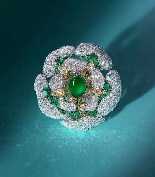 A ring designed in the form of a flower. At its center is a prominent, oval - shaped green gemstone. Surrounding it are smaller green stones and numerous small, brilliant diamonds that mimic the petals and details of a flower, with some gold accents adding a warm touch.