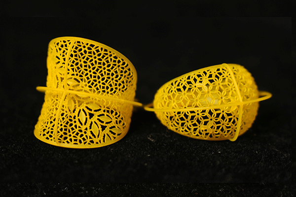 Two yellow bracelet prototypes made of castable resin, featuring intricate lace - like and geometric lattice patterns