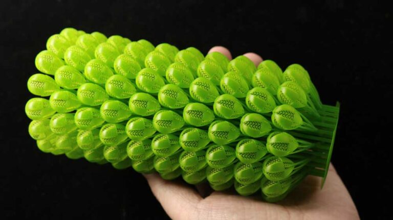 Multiple 3D printed green resin earrings in hand