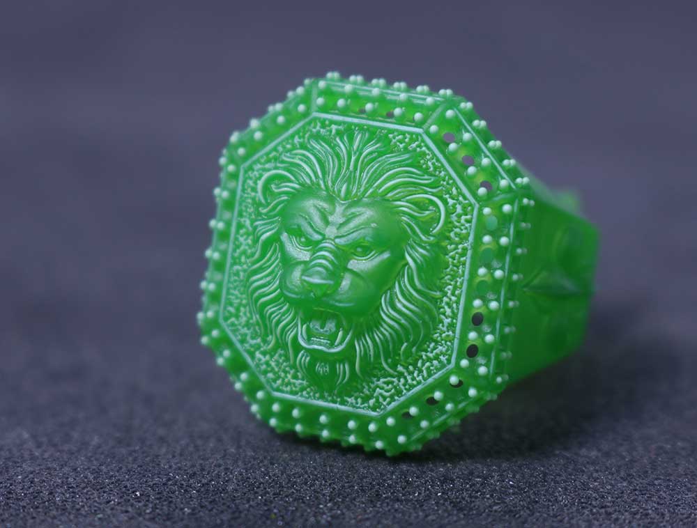 3D printed green casting resin signet ring with an octagonal face, detailed lion head relief, and beaded border