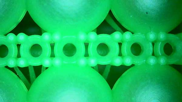 Magnified detail of 3D - printed wax - based resin ring: linear gem - setting holes with 0.25mm precision