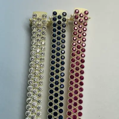 Three 3D printed castable resin tennis bracelet models pre-set with white, blue, and pink simulated diamonds.