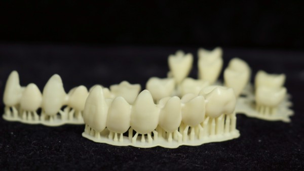 A collection of 3D printed crowns and bridges highlighting the versatility of permanent crown resin for restorative dentistry.