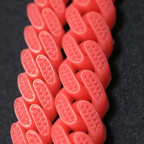 A 3D printed red wax Cuban link bracelet featuring detailed honeycomb-style stone settings for diamond pavé