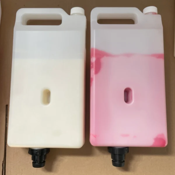 Two plastic containers of 3D printing wax, one white build material and one pink support material.