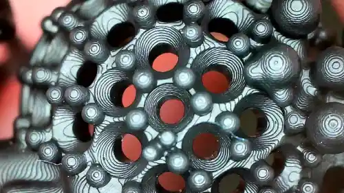 Macro shot of a 3D printed jewelry piece showing prominent layer lines and the staircase effect on a black castable resin model, illustrating the need for surface smoothing.