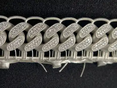 A raw, high-precision metal Cuban link bracelet fresh from lost-wax casting with supports, demonstrating zero ash residue and smooth surface quality using 800D wax resin.