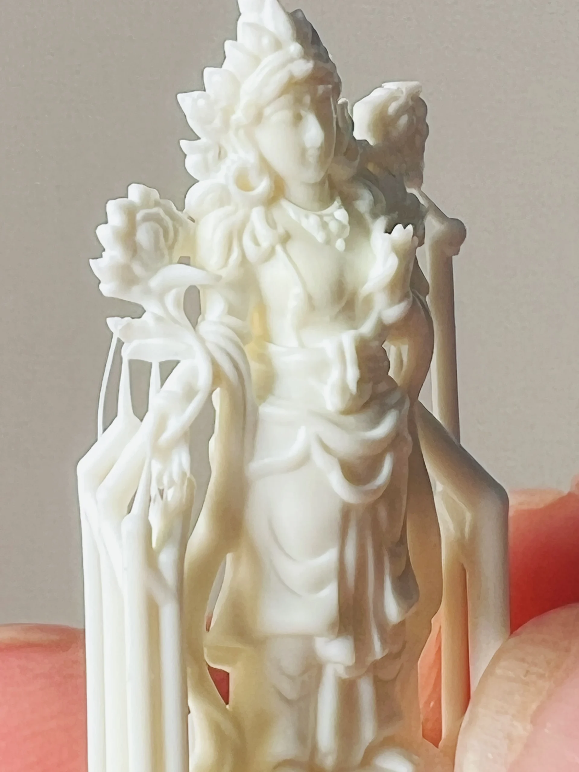 Close-up front view of 3D printed Bodhisattva pendant with support structure in 800D white wax resin