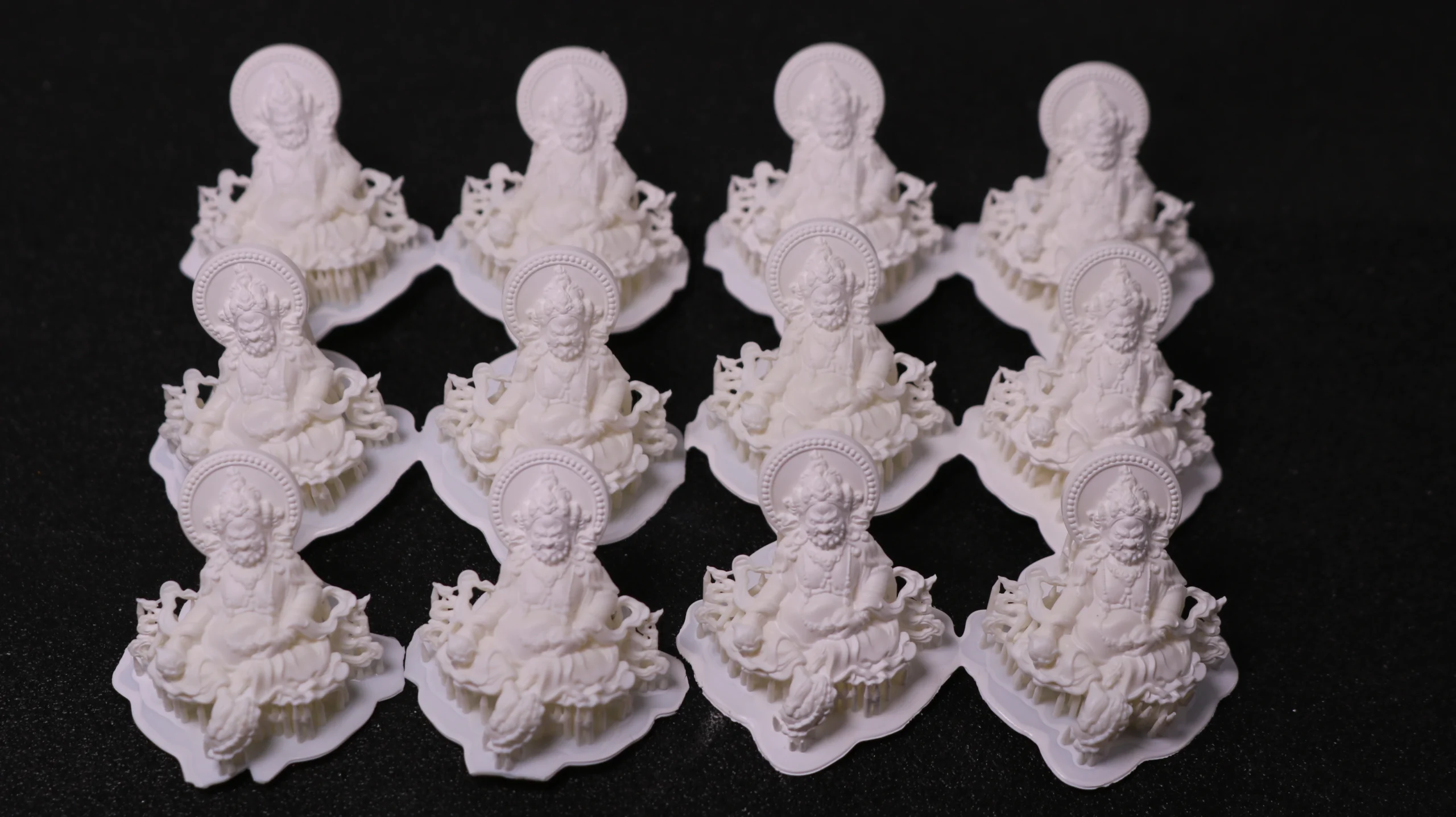 Top view batch array of 12 3D printed Buddha figure pendants made with 800D white wax resin