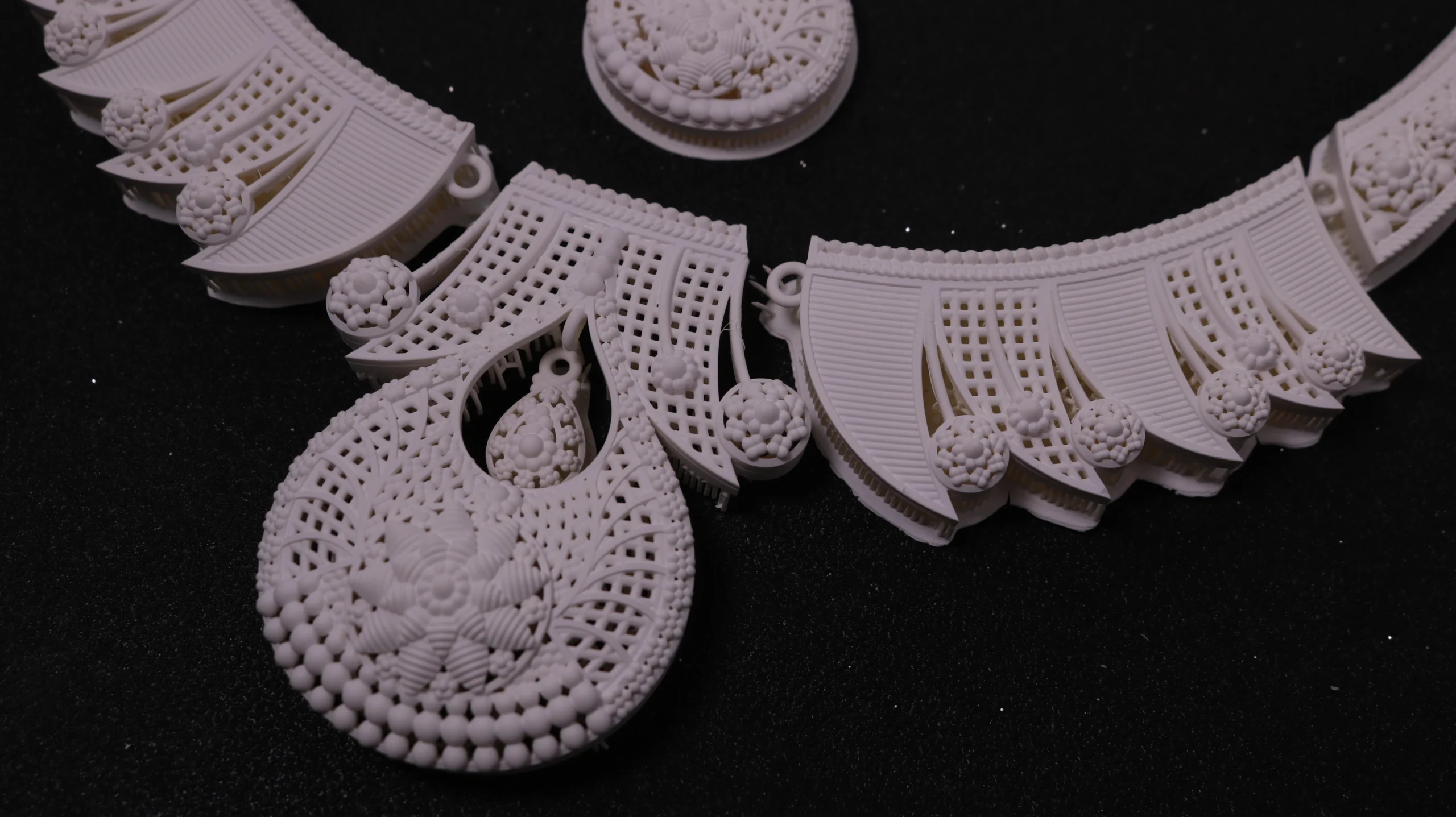 Close-up view of intricate 3D printed modular carved filigree necklace details in 800D white wax resin