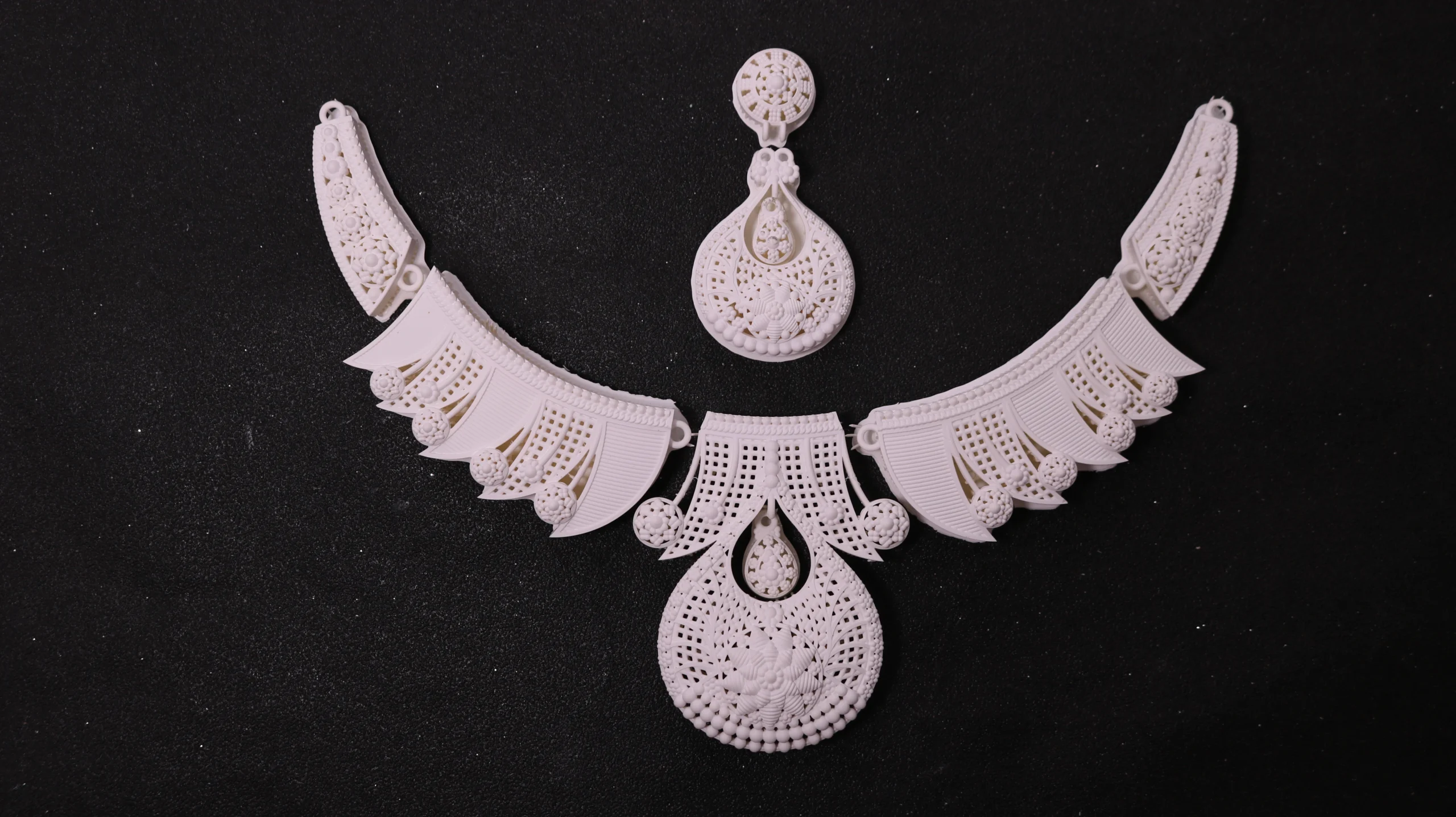 Top view flat lay of 3D printed modular carved filigree necklace set in 800D white wax resin