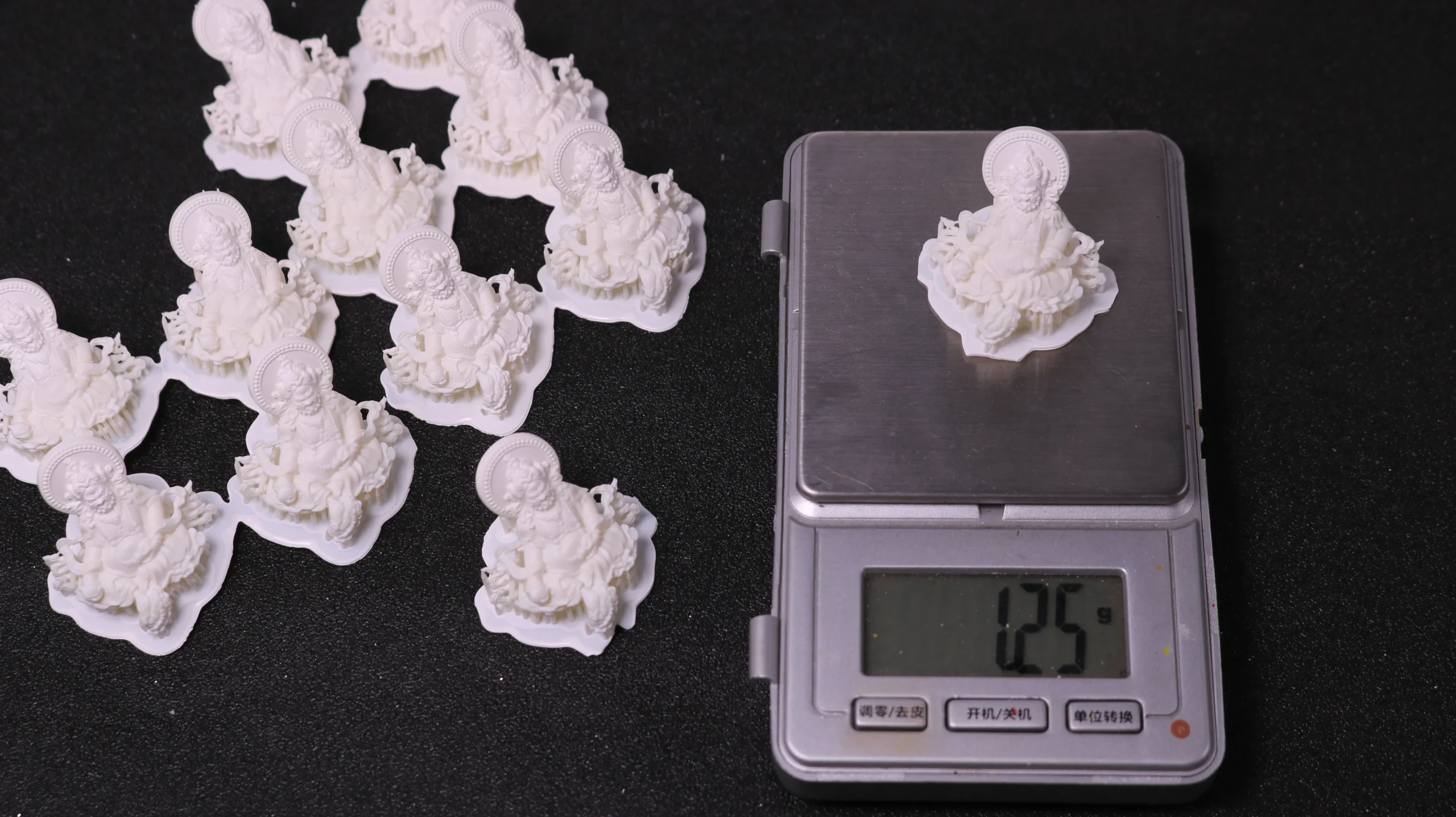 3D printed 800D white wax resin Buddha pendant on digital scale showing 1.25g weight