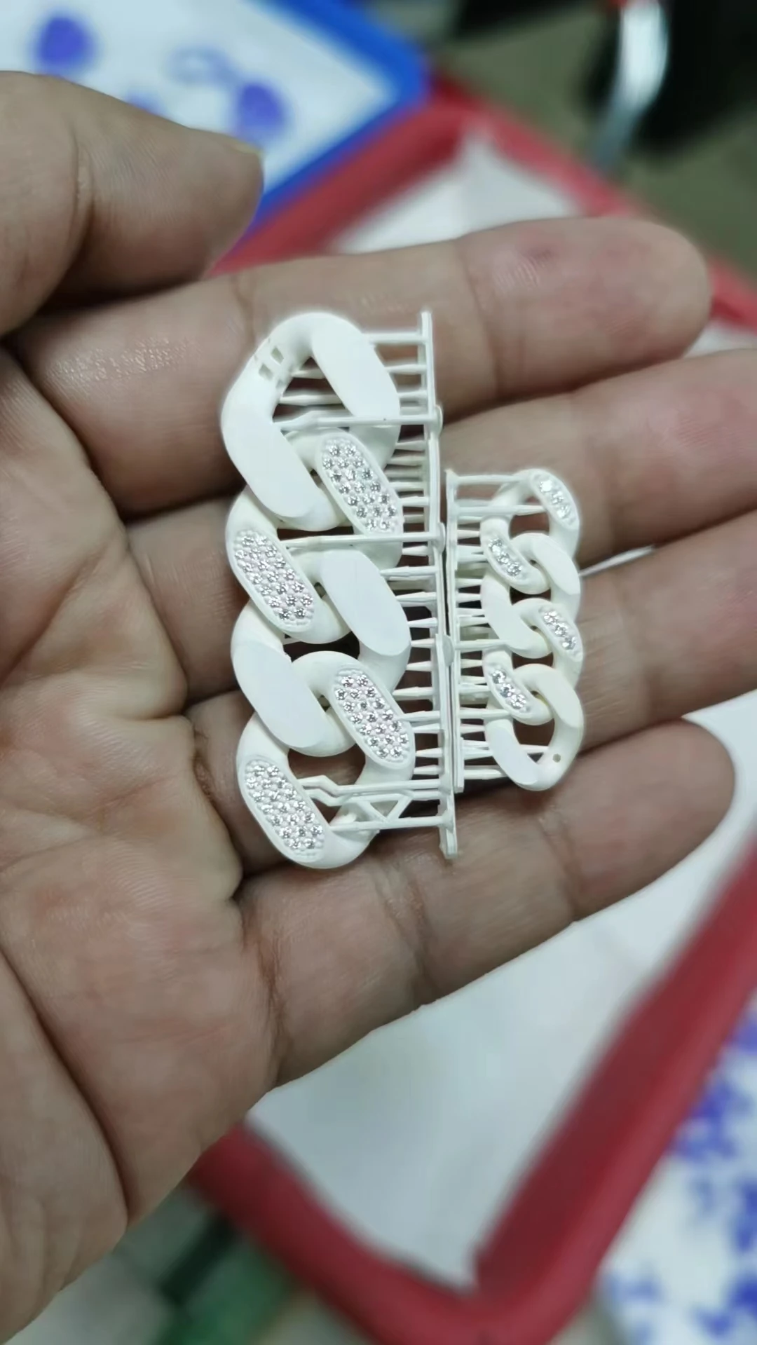 Hand-held close-up of 800D white wax resin 3D printed Cuban link pattern with pre-set stones