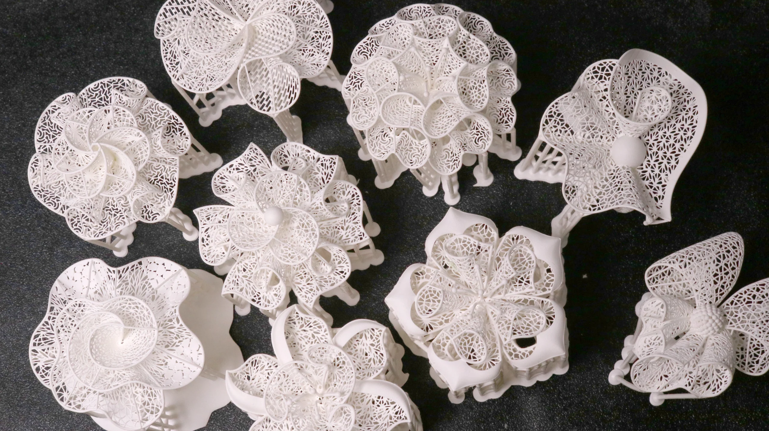 Top view array of multiple 3D printed complex floral blossom ring patterns in 800D white wax resin