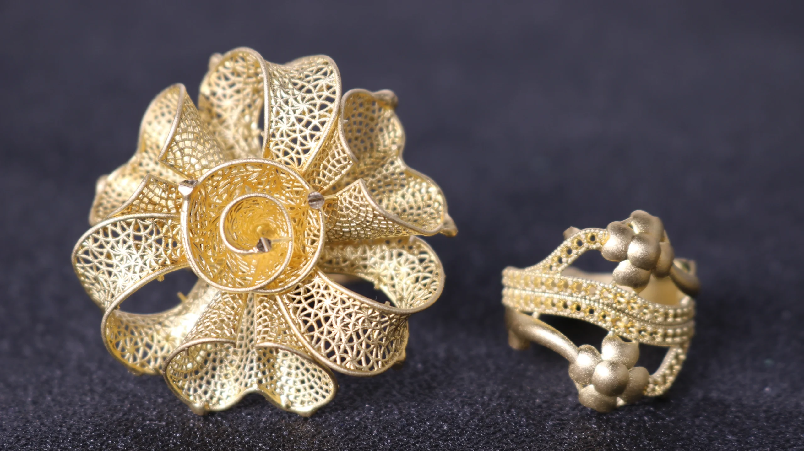 Front view of raw unpolished gold cast rings featuring filigree blossom and pave setting holes